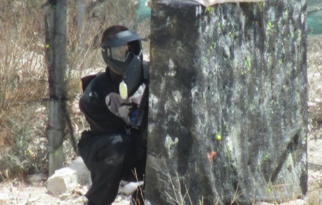  man behind a wall playing paintball